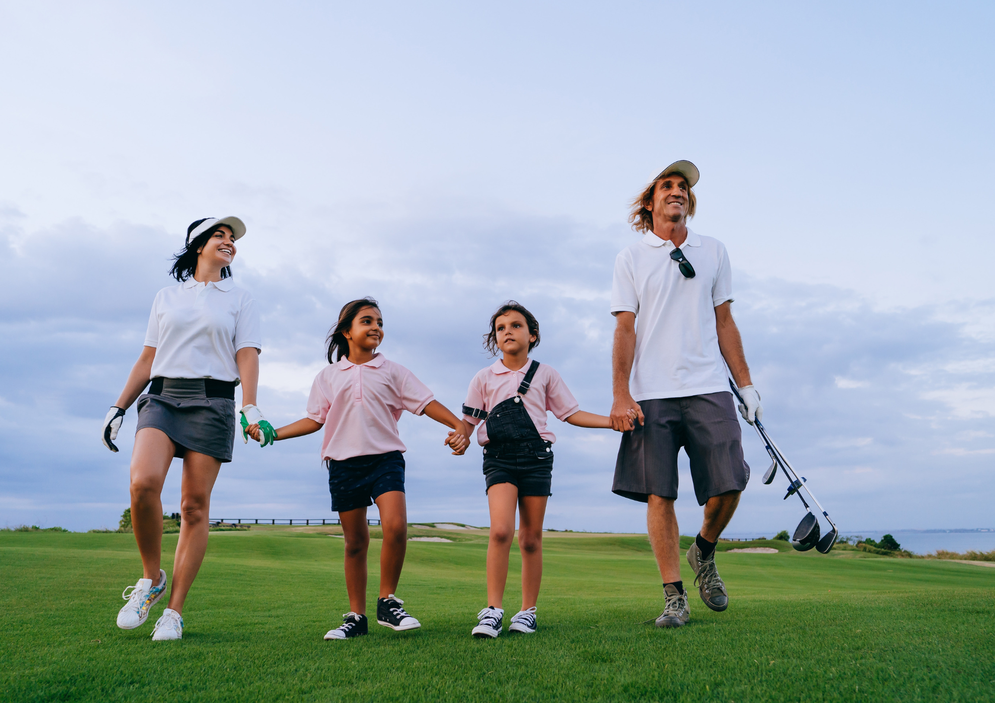 Famille sur le fairway, découverte du golf en plein air.