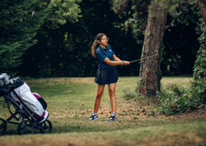Jeune golfeur avec sac de golf junior sur un parcours.