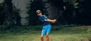 Jeune enfant au golf développant patience et concentration sur le green
