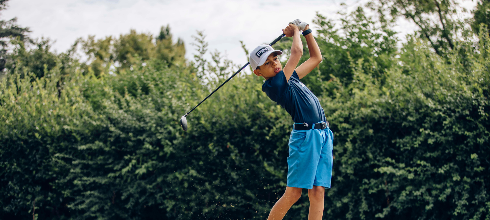 Jeune golfeur en pleine concentration sur un parcours verdoyant