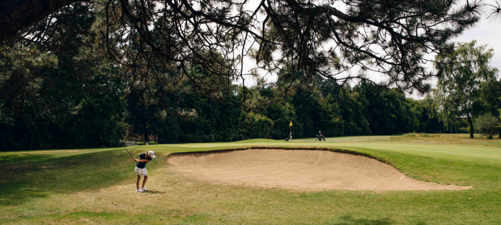 Adolescent jouant au golf sur un parcours verdoyant, une activité de sport extérieur calme et stratégique