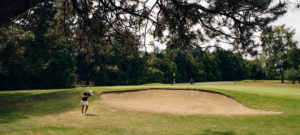 Adolescent jouant au golf sur un parcours verdoyant, une activité de sport extérieur calme et stratégique