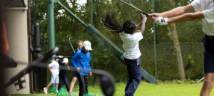 Jeunes golfeurs en initiation sur un green avec clubs adaptés à sa taille