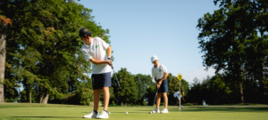 Jeune golfeur souriant s'entraînant au practice après l'école, ambiance détendue.
